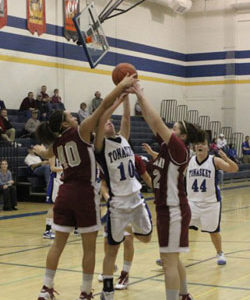 Tonasket junior Michelle Carlson tries to make a shot despite some Okanogan Bulldog’s best efforts to tip it during Tonasket’s home game on Tuesday, Feb. 2. Photo by Terry Mills