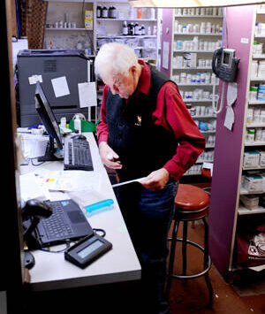 Dick Larson fills a prescription at Oroville Pharmacy. The business will close at the end of the year and Larson will retire. The store will open to its new owner sometime in 2025. <em>Gary De Von/staff photo</em>